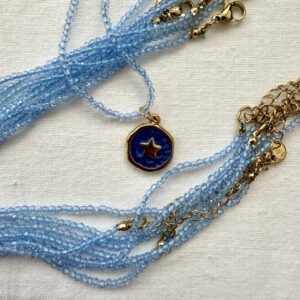 Collana in acciaio dorato con cristallo azzurro trasparente